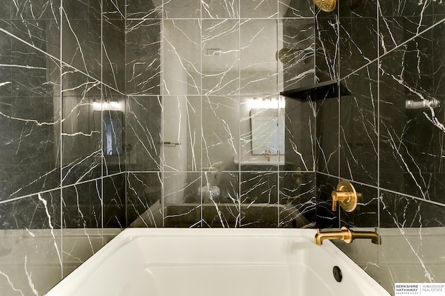 bathroom with tile walls and tiled shower / bath