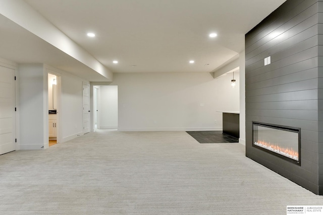 unfurnished living room featuring a large fireplace and light carpet