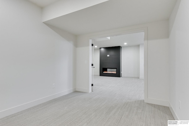 unfurnished room featuring a fireplace and light carpet