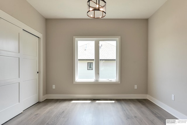 interior space featuring light hardwood / wood-style floors, a chandelier, and a closet