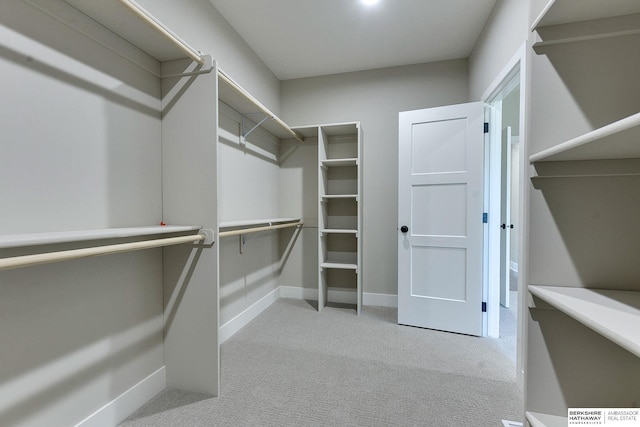 walk in closet featuring light carpet