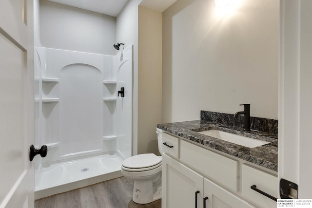 bathroom with walk in shower, vanity, toilet, and hardwood / wood-style flooring