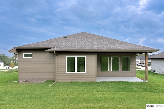 rear view of property featuring a patio and a lawn