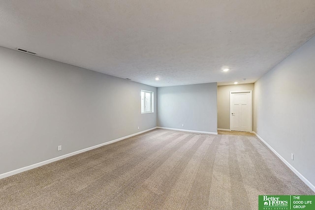 spare room with light colored carpet and a textured ceiling