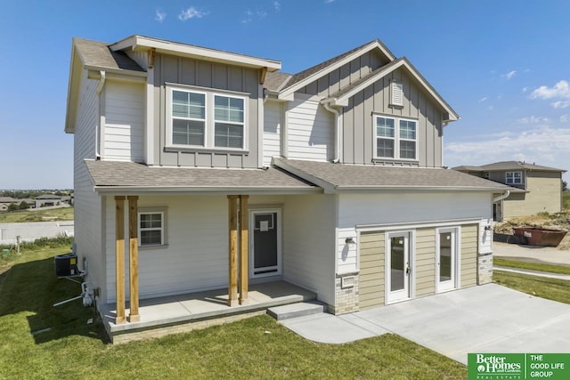 rear view of property with central AC and a yard