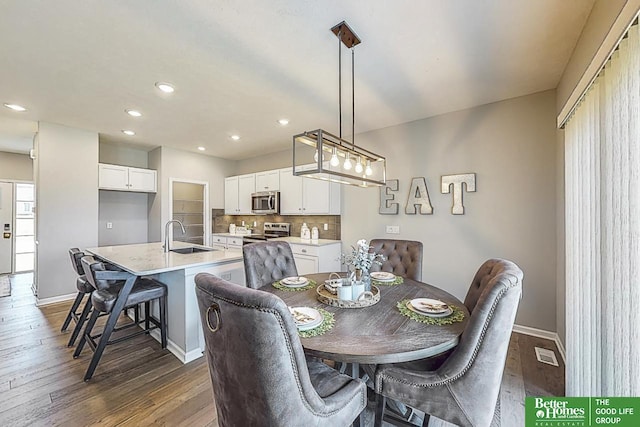 dining area featuring dark wood-type flooring and sink