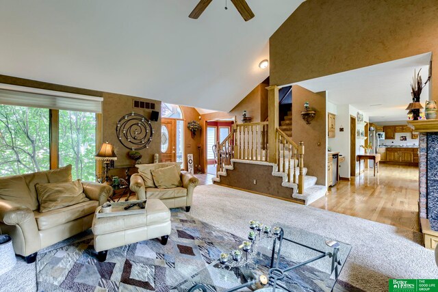 living room featuring ceiling fan, wood-type flooring, and high vaulted ceiling