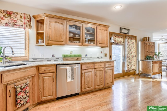 kitchen featuring dishwasher, light wood-type flooring, plenty of natural light, and sink