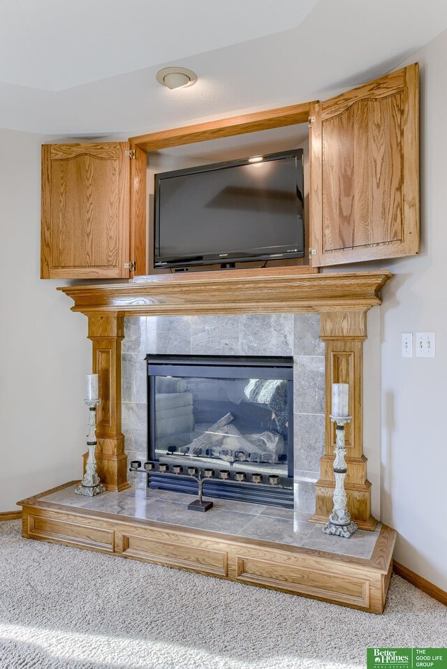 interior details with carpet flooring and a tile fireplace