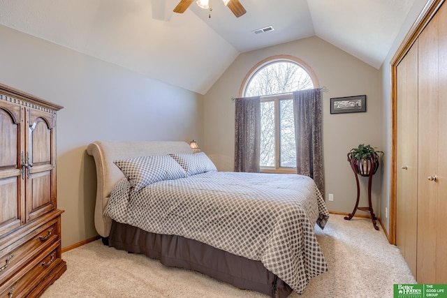 carpeted bedroom with a closet, lofted ceiling, and ceiling fan