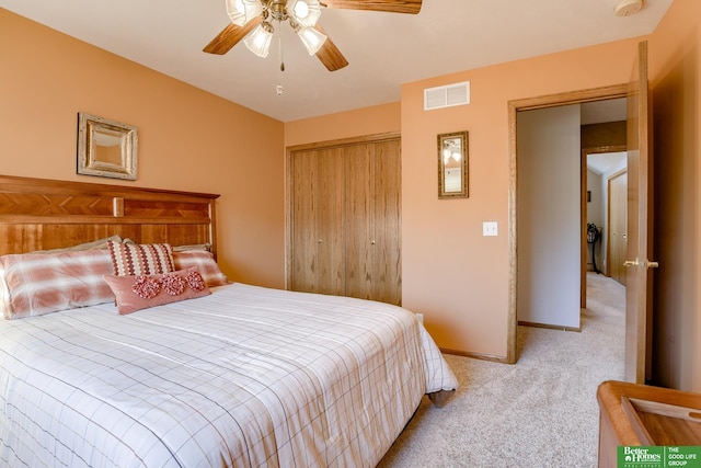 bedroom featuring light colored carpet, ceiling fan, and a closet