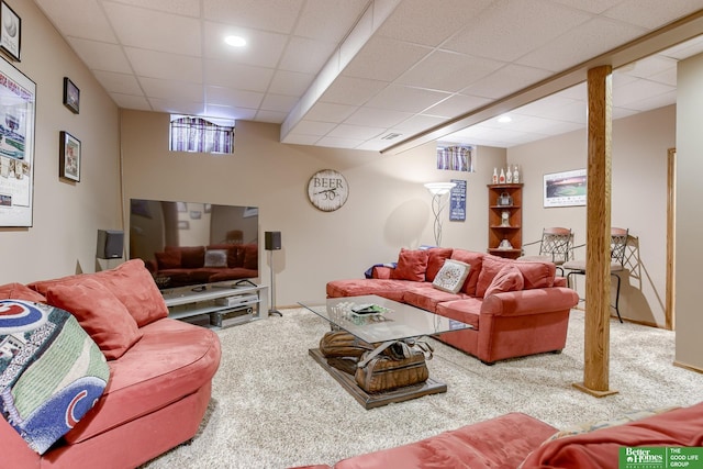 living room featuring carpet flooring and a drop ceiling