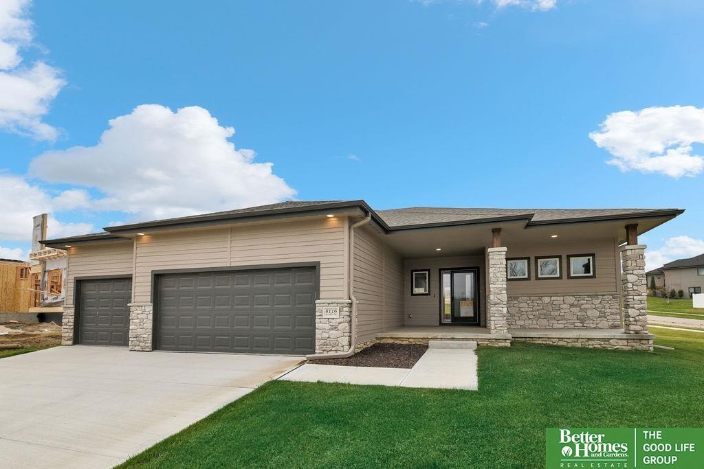 prairie-style house featuring a garage and a front lawn