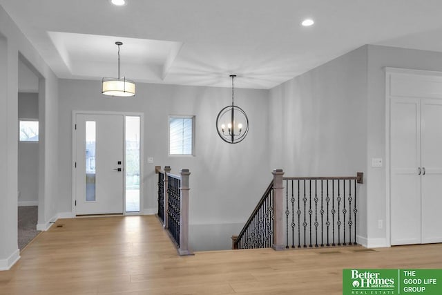 entryway featuring light wood-type flooring and a notable chandelier