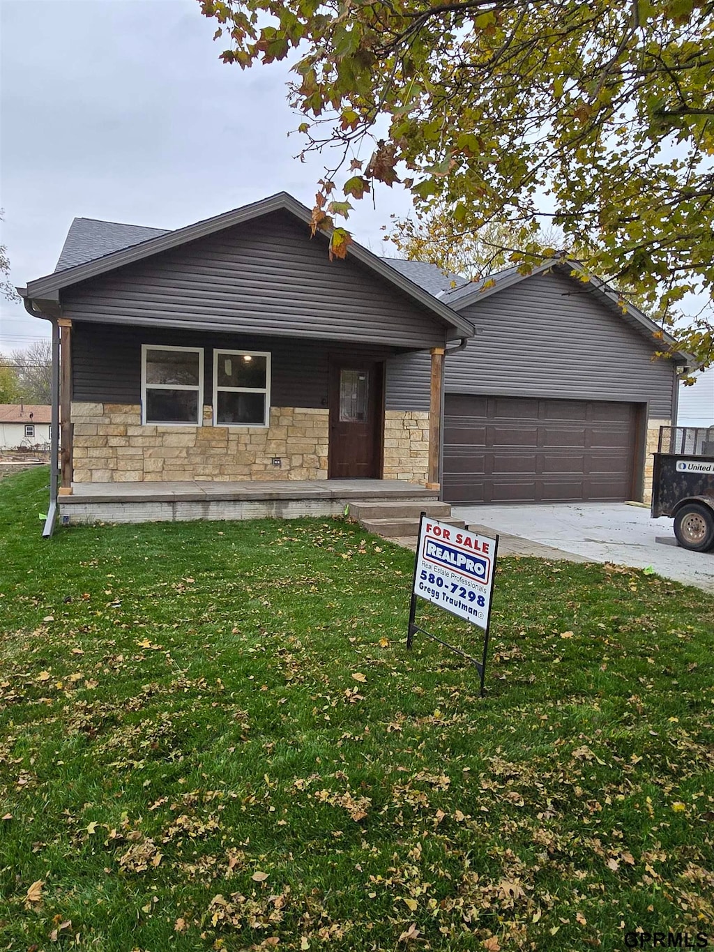 ranch-style home featuring a garage and a front lawn