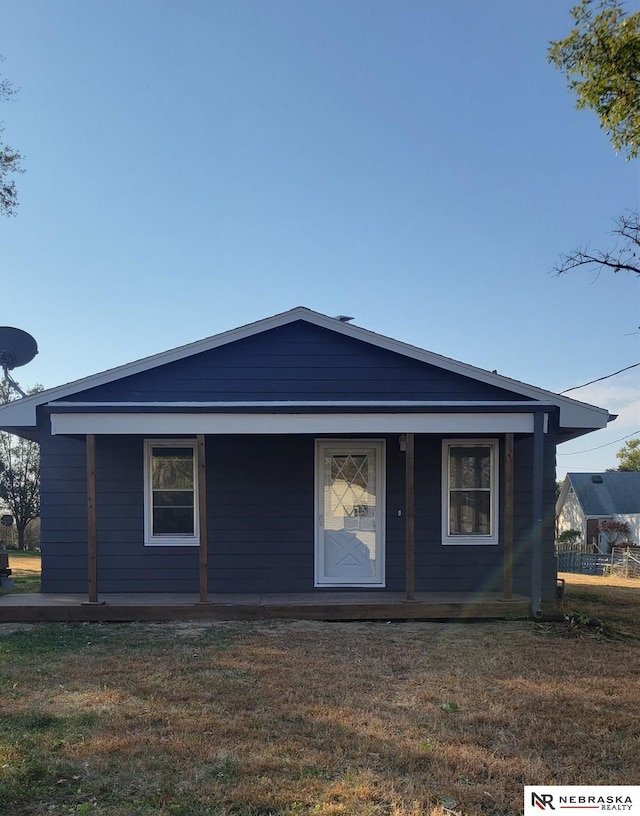 back of house featuring a porch and a lawn