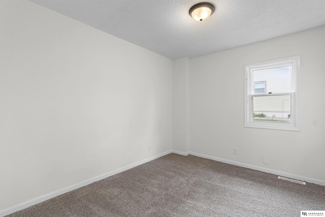 carpeted empty room with a textured ceiling