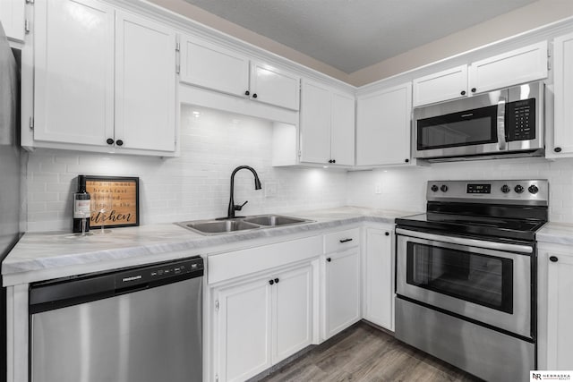 kitchen featuring dark wood-type flooring, white cabinetry, sink, and stainless steel appliances