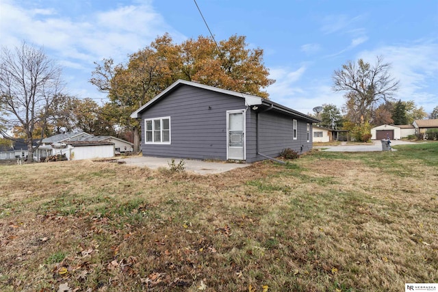 back of property with a lawn and a patio