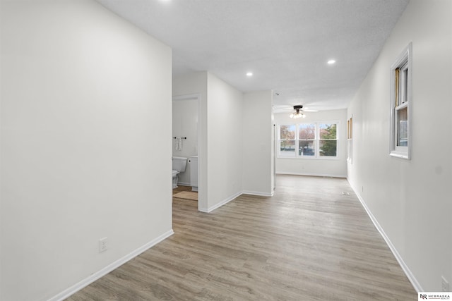 hallway featuring a textured ceiling and light hardwood / wood-style floors