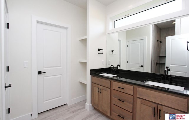 bathroom with hardwood / wood-style floors, walk in shower, and vanity