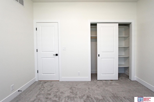 unfurnished bedroom featuring a closet and light carpet