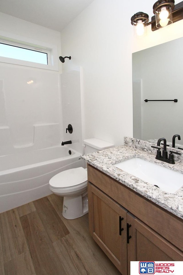 full bathroom featuring toilet, vanity, hardwood / wood-style floors, and  shower combination