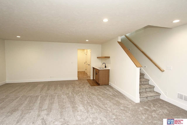 unfurnished living room with light carpet and sink