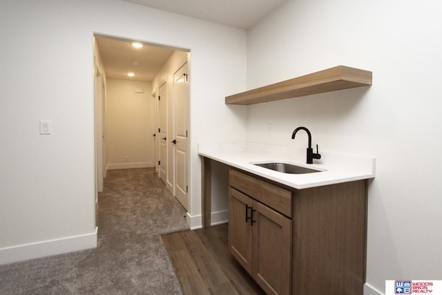 kitchen featuring dark colored carpet and sink