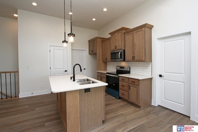 kitchen featuring black range with electric stovetop, sink, wood-type flooring, and a kitchen island with sink