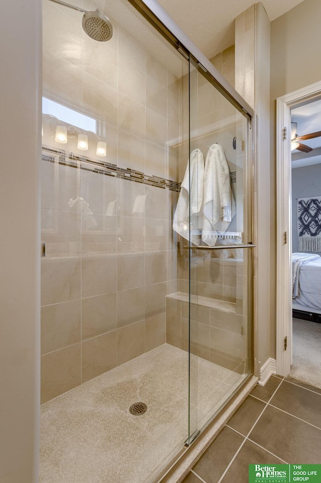 bathroom featuring ceiling fan, tile patterned floors, and a shower with shower door