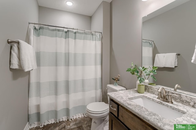 bathroom with walk in shower, vanity, and toilet