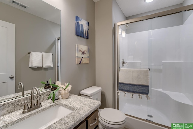 bathroom with vanity, toilet, and a shower with shower door