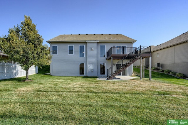 rear view of property with a wooden deck and a yard