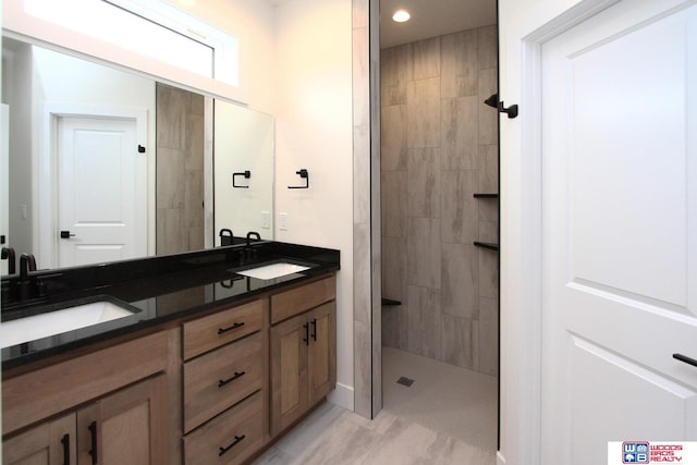 bathroom featuring vanity, tile patterned floors, and a tile shower