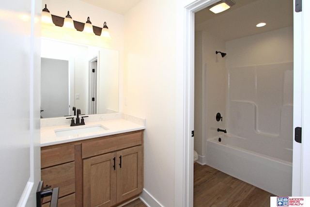 full bathroom featuring vanity, hardwood / wood-style flooring, toilet, and tub / shower combination