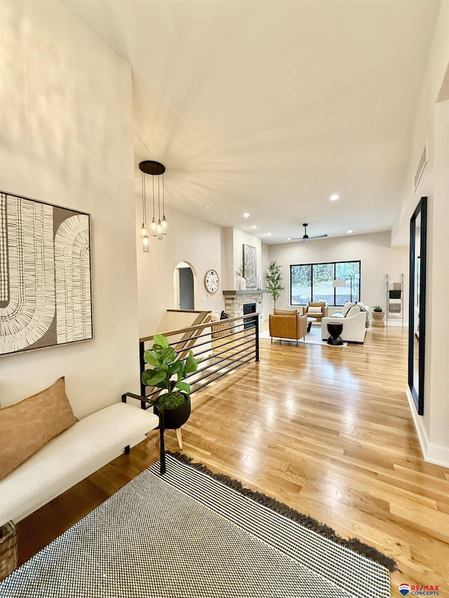 living room with hardwood / wood-style floors and ceiling fan with notable chandelier