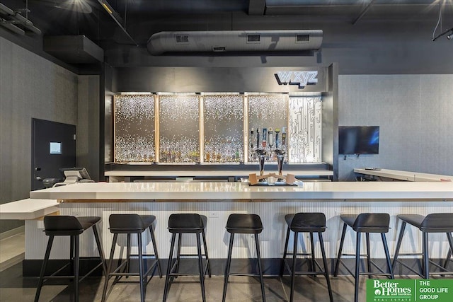 kitchen with a kitchen breakfast bar and concrete flooring