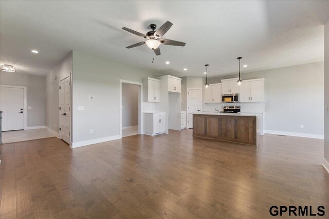 216 St Andrews Loop, Malvern, IA 51551 - unfurnished living room with ceiling fan, baseboards, recessed lighting, dark wood finished floors, and a sink