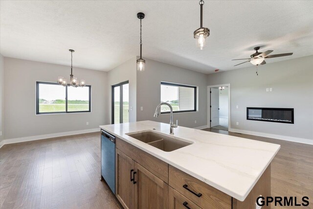 216 St Andrews Loop, Malvern, IA 51551 - kitchen featuring a sink, open floor plan, stainless steel dishwasher, and baseboards
