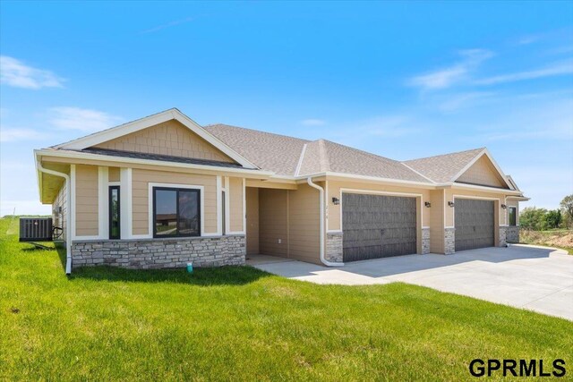 216 St Andrews Loop, Malvern, IA 51551 - view of front facade with a garage, central air condition unit, a front yard, and stone siding