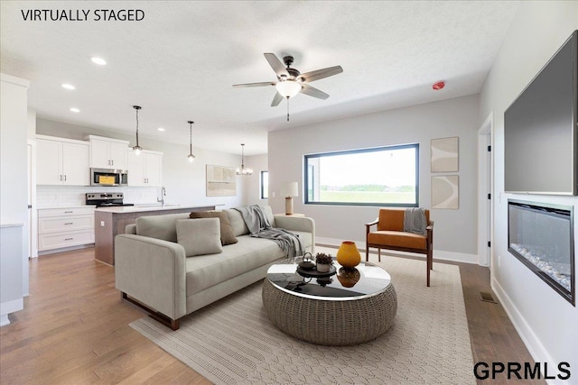 216 St Andrews Loop, Malvern, IA 51551 - living room featuring recessed lighting, wood finished floors, a ceiling fan, and baseboards
