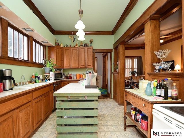 kitchen featuring tile countertops, sink, ornamental molding, hanging light fixtures, and a kitchen island