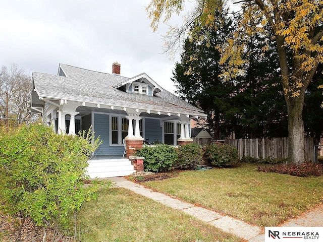 view of front of house with a front yard and covered porch