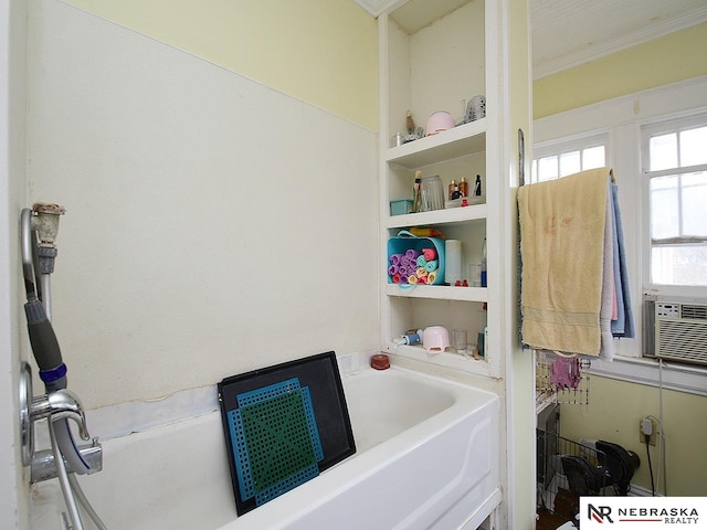 bathroom featuring crown molding and a bathing tub