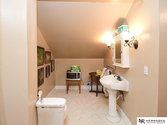 bathroom with toilet and lofted ceiling