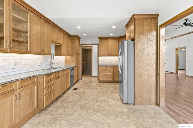 2119 N 144th Ave, Omaha, NE 68116 - kitchen featuring stainless steel appliances, a sink, light stone counters, a ceiling fan, and tasteful backsplash