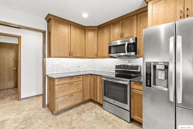2119 N 144th Ave, Omaha, NE 68116 - kitchen with stainless steel appliances, dark stone counters, tasteful backsplash, brown cabinetry, and recessed lighting