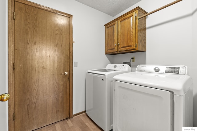 2119 N 144th Ave, Omaha, NE 68116 - laundry room featuring independent washer and dryer, cabinet space, and light wood-style flooring