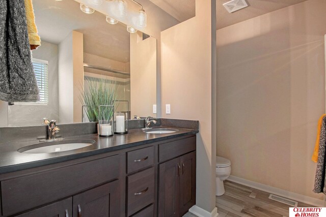 bathroom featuring hardwood / wood-style floors, vanity, and toilet